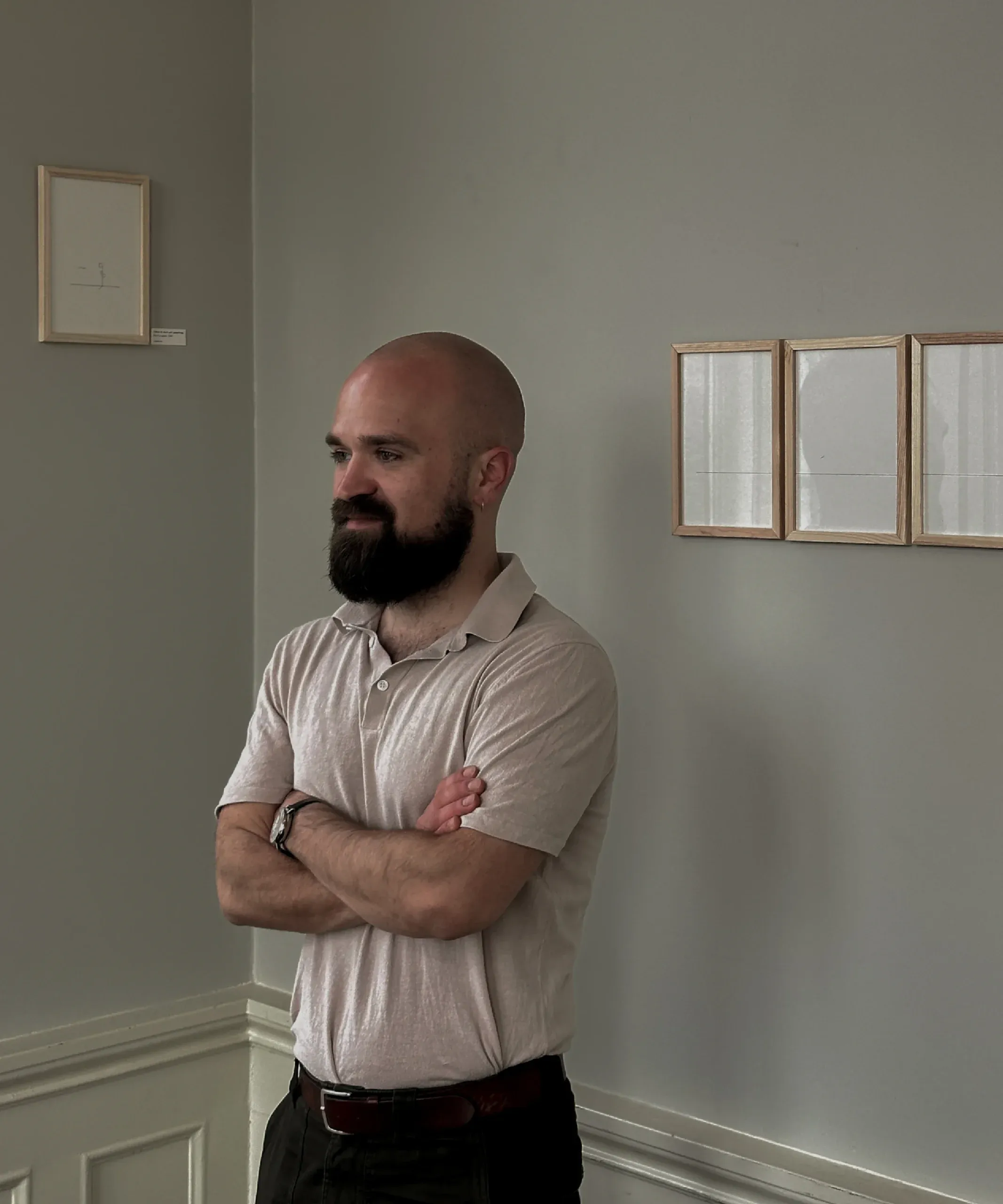 Frederik Smal standing beside his framed drawings in Reykjavík, 2025.
