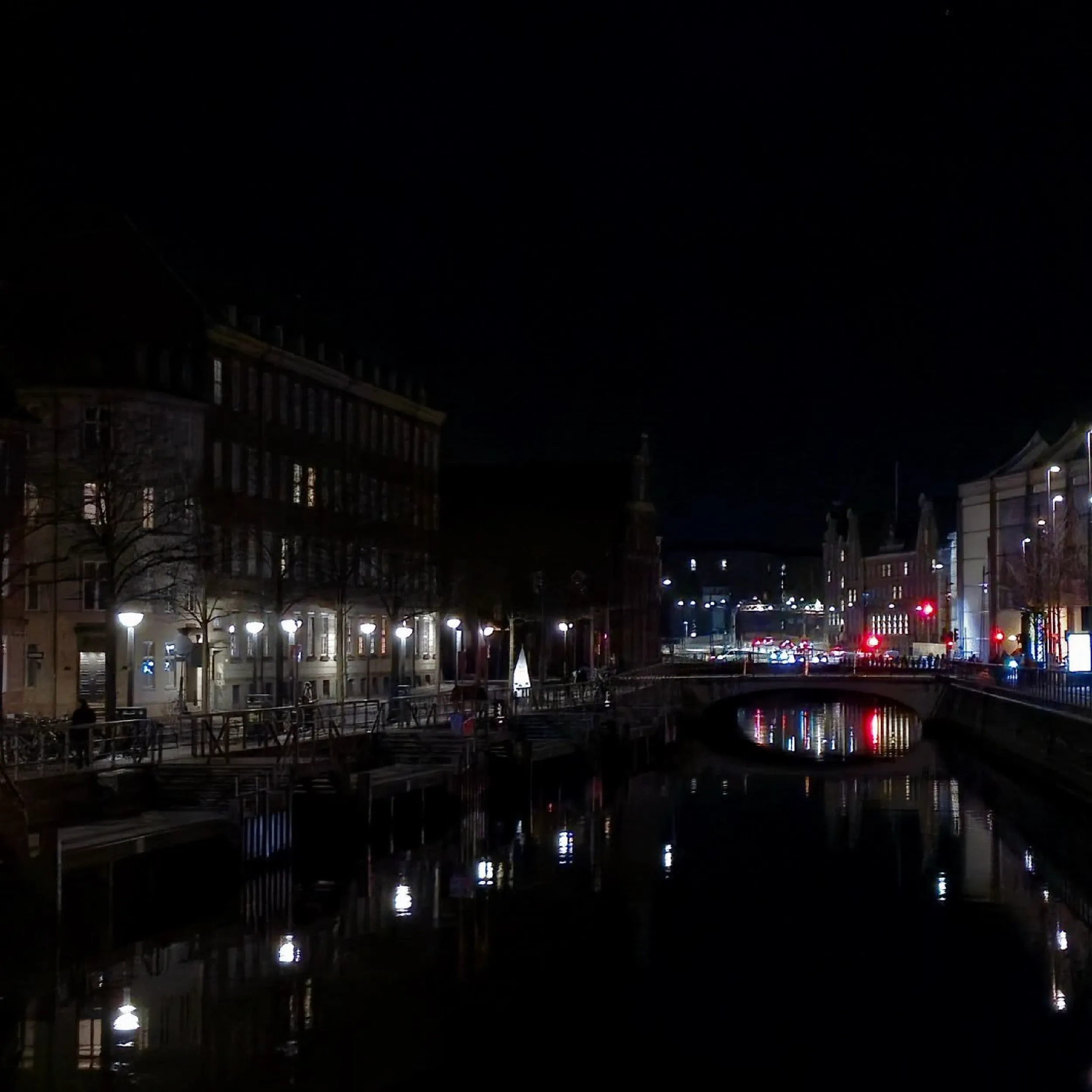 Night view of a Copenhagen canal and bridge during the light festival.